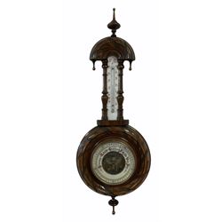 An Edwardian carved pendant framed hall barometer with a compensated Aneroid movement by the German maker Julius Gischard, open porcelain four-and-a-half-inch dial measuring barometric air pressure from twenty-seven to thirty-one point nine inches, weather predictions written in upper and lower case gothic script with initial letters highlighted in red, blue steel indicating hand and brass recording hand, dial bezel with flat bevelled glass, mercury thermometer recording temperature in degrees Fahrenheit and Celsius, scale written in red Arabic numerals on an unglazed opal plate with arched crest above, Julius Gischard was one of the five traditional Hamburg barometer manufacturers whose history dates back to the 19th century, founded in 1874 by Christian Julius Friedrich Gischard and his companion J. Heinrich Saul, the company manufactured and exported many barometers to England during the 19th and 20th century.