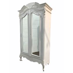 French style white armoire, the arched top over two bevel glazed mirrored doors enclosing two adjustable shelves and hanging rail, flanked by acanthus leaf corbels, raised on scrolled cabriole supports 