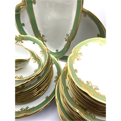 Dresden dinner service decorated with a green and gilt border pattern comprising twelve dinner plates, nine dessert plates, nine soup bowls, nine side plates, soup tureen with cover and stand, two open serving dishes, two circular platters, sauce boat and stand and a meat plate (47) 