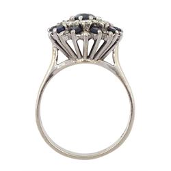 White gold sapphire and diamond cluster ring, the central oval cut sapphire, with round cut sapphire and round brilliant cut diamond surround, stamped 18ct, 