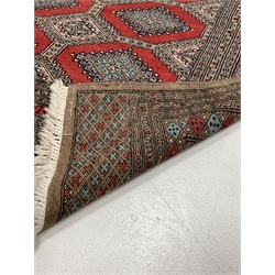 Persian design grey ground Bokhara rug, repeating red and blue gul motif, enclosed by multi line border