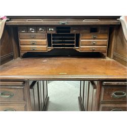20th century mahogany roll top desk, the tambour top enclosing fitted interior over six short and one long drawer, raised on a plinth base, together with oak roll top desk of similar design 