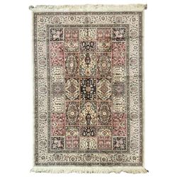 Indian design ivory ground rug, the field with various panels depicting Mirab motifs and foliate compositions with urn designs, in rose and indigo tones, the guarded border with repeating palmettes with stylised plant motifs