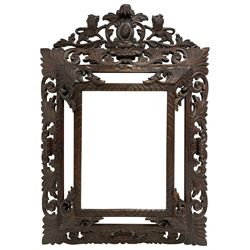 Large Victorian cushion framed wall mirror, the carved and pierced pediment with central cartouche flanked by two standing lions and foliate c-scrolls, the frame carved with scrolling foliage and incised decoration, the main bevelled mirror plate surrounded by plain plates, mounted by scrolled foliage corner brackets