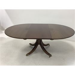 Late 20th century Regency design mahogany dining table, the oval top with one additional leaf raised on a turned column and four splayed supports terminating in brass hairy paw castors, by Gotts of Pickering 197cm x 137cm, H73cm