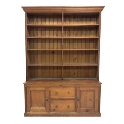 Late Victorian pine dresser, the projecting cornice over a four height plate rack over base fitted with two drawers and two cupboards, raised on a plinth base 