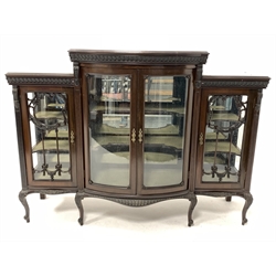 Early 20th century mahogany display cabinet, the central bowed section with bevelled glazed double doors enclosing two shelves, flanked by two further glazed cupboards, raised on cabriole supports 