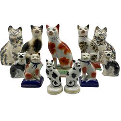 Three Victorian style Staffordshire pottery cat ornaments seated on cushions H17cm, a pair of cats with sponged decoration and various others (11)