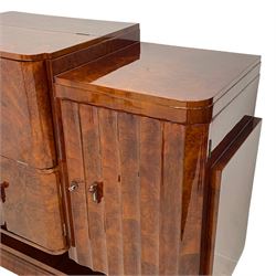 Attributed to Harry & Lou Epstein - Art Deco circa. 1930s figured walnut sideboard, central fall-front cocktail cabinet with raised top enclosing mirrored interior with bottle insets, over double cupboard, flanked by scalloped fluted doors concealing shelves and rotating bottle stand, curved supports on undertier with moulded base