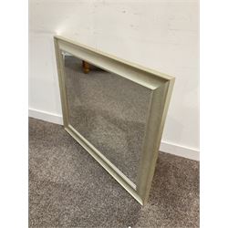 Contemporary wall hanging mirror in a swept silver frame 