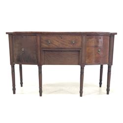 George IV mahogany break bowfront sideboard, with ebonised string inlay, fitted with three drawers and a cupboard, raised on ring turned supports W154cm, H91cm, D58cm