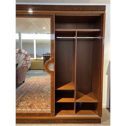 John Nicholas Bespoke Furniture - contemporary designer large walnut double wardrobe, the banded figured cornice over a curved open set of shelves and two mirrored sliding doors, the plates surrounded by figured bands and ebony stringing, the fitted interior comprising of hanging rails and shelves