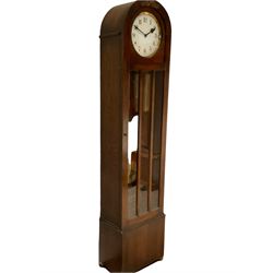 English - 1930's Westminster chime 8-day oak longcase clock, with a rounded top and full length three panel glazed door, visible pendulum and three brass-cased weights, circual painted dial with Arabic numerals and spade hands, three train chain driven movement with strike/silent facilty.