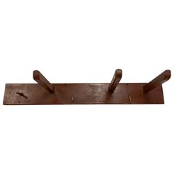 19th century painted pine wall hanging tack or saddle rack, fitted with three projecting rests, turned wooden hook and two wrought metal hooks, on chamfered rectangular mount 