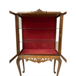 Mid-20th century walnut display cabinet, fitted with two glazed doors, opening to reveal two glass shelves, surmounted by scrolled pediment, raised on cabriole supports with acanthus leaf carving