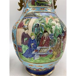Pair of Chinese Canton Famille Rose twin handled vases, each of baluster form, decorated in low relief with four opposed shaped rectangular panels depicting dignitaries and attendants in a garden setting, the blue ground painted in iron red and gilded with dragons chasing the flaming pearl, within ruyi panel and greek key borders, unmarked, H30cm 