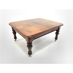 Large Victorian mahogany wind out extending dining table, the rectangular moulded top with rounded corners raised on turned carved supports terminating in brass cup and ceramic castors, 