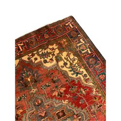 Persian Hamadan red ground rug, shaped central medallion with extending stylised plant motifs, the field decorated with stylised leaf and flower head motifs, paler spandrels with further foliate decoration, the main border with repeating stylised pattern within guard stripes