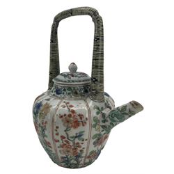 Chinese famille verte porcelain wine pot with associated cover, Kangxi period, with lobed tapering body and tall arch handle in imitation of bamboo, painted with butterflies, insects, rockwork and flowers, H19cm. Provenance: From the Estate of the late Dowager Lady St Oswald