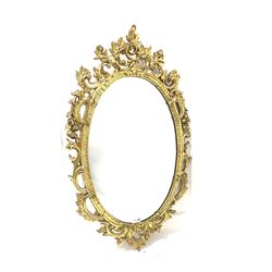 Ornate gilt framed oval wall mirror with floral scrolled decoration 57cm x 97cm