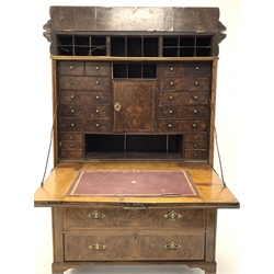 Early Georgian walnut escritoire,  the cushion fronted frieze lifting to reveal a concealed compartment fitted with cubby holes, over a well figured and cross banded fall front enclosing drawers, cupboards and sloped skivered writing surface, chest under fitted with two short and two long drawers with herrigbanded faces, raised on shaped bracket supports, W113cm, H,177cm D52cm