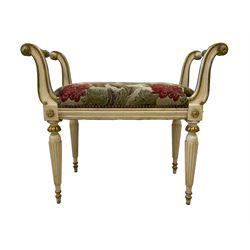 Pair Louis XVI design ivory and gilt painted dressing stools, the scrolled side rests united by stretcher with acanthus leaf moulding, upholstered in foliate fabric with studwork border, raised on reeded tapering supports