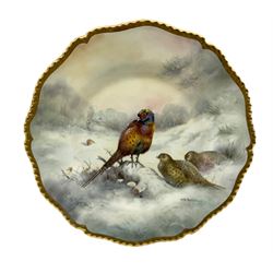 20th century shaped cabinet plate by Richard Budd, hand painted with Pheasants in a snowy sunset landscape, within a gilt moulded border, signed R. Budd, D27cm 