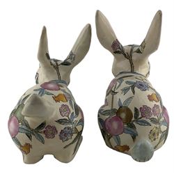 Pair of mid 20th century Chinese pottery Rabbits, each in a different pose and enamelled with fruit and flowering branches, H27cm max