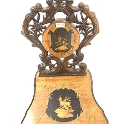 Late 19th century Swiss walnut music chair, the back rest carved with flower heads, plants and conforming scrolls centred by a penwork panel, the shaped seat with marquetry and penwork housing wind up cylindrical music box, raised on cabriole supports