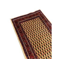 Persian Aarak golden wheat ground runner, the field decorated with repeating Boteh motifs, the main border band with trailing design interspersed with stylised geometric motifs, within guard bands