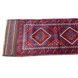 Meshwani indigo and maroon ground runner rug, the field decorated with four central lozenges within geometric borders, the outer band with repeating alternating geometric shapes