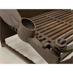 Wrought and cast iron dog grate, (W76cm, D48cm) together with a pierced brass and iron fire fender, (W120cm)