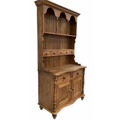 Victorian style waxed pine dresser, two height plate rack fitted five spice draws over the base with serpentine top, two draws and a double cupboard enclosing shelf, raised on turned supports, W 107cm.