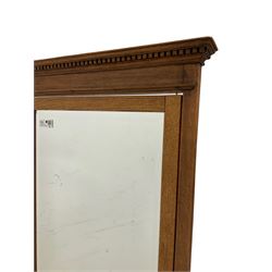 Late Victorian oak cheval mirror, moulded dentil cresting rail over rectangular swing mirror, on splayed supports with cast brass paw castors, bevelled plate