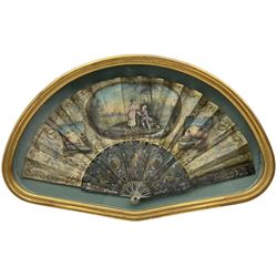 18th century French fan, the mother-of-pearl sticks carved, pierced, silvered and gilded, the silk leaf painted with panels of landscapes and a young couple with a birdcage, the leaf edged with scrolled borders, star and circular shaped gold coloured sequins and thread, framed and glazed, L61cm x H37cm. Provenance: From the Estate of the late Dowager Lady St Oswald