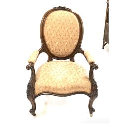 Victorian mahogany open armchair, the shaped crest rail carved with foliate pediment, scrolled and floral carved arm terminals leading to scrolled cabriole front supports and castors, back arms and seat upholstered in salmon fabric, W63cm