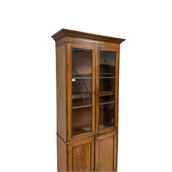 19th century mahogany bookcase on cupboard, the projecting cornice over two glazed doors and two cupboard doors, raised on bracket supports 