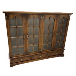 Royal Oak Furniture - oak bookcase with four glazed doors, opening to reveal three fixed shelves, over three drawers 