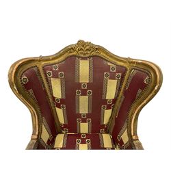 Pair Louis XV design gilt framed wingback armchairs, the cresting rail carved and moulded with a central cartouche and extending scrolling, the apron and knees decorated with flower heads, raised on cabriole supports, upholstered in maroon patterned fabric with sprung seat studwork