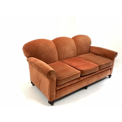 Early to mid 20th century three seat sofa, with serpentine back over loose cushions, raised on turned walnut front supports and replaced castors, upholstered in salmon velvet, W183cm, D95cm