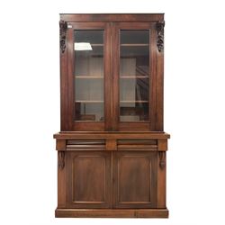 Late 19th century mahogany bookcase, fitted with two glazed doors enclosing three adjustable shelves, flanked by scrolled corbels with acanthus decoration, lower section fitted with two drawers over two panelled cupboard doors, raised on plinth base