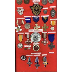 Glazed display case containing a collection of German Third Reich medals and badges including silver German Cross, the pin marked '21', three Dr Fritz Todt medals in bronze, silver and gold each marked '8244' to the reverse, Order of the German Eagle 4th Class with white enamel cross, the pin marked '900' and three other Orders of the German Eagle, gold, silver and bronze Mothers Crosses, Fire Service and Police medals