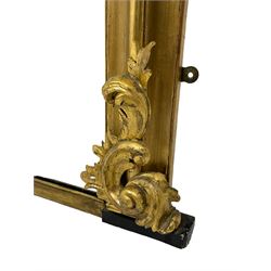 19th century ornate giltwood framed overmantel mirror, the moulded frame mounted by scrolled foliage carvings to the pediment and lower brackets, plain mirror plate