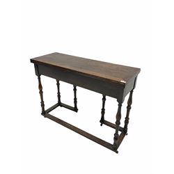 Early 20th century oak console table, the rectangular fold over top with double gate leg action, raised on turned supports with floor stretcher, terminating in castors 