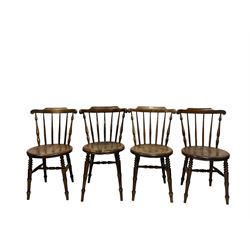 Near set four beech chairs, the shaped cresting rail over spindle back and circular seat, raised on turned supports, united by stretcher 