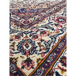 Persian hand knotted rug, with red and blue central medallion and ivory field with ivory border and overall floral decoration 364cm x 280cm
