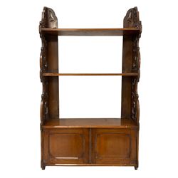 Late 19th century walnut wall hanging bookcase, fitted with two shelves and double panelled cupboard, fretwork end supports decorated with scrolling foliage 
