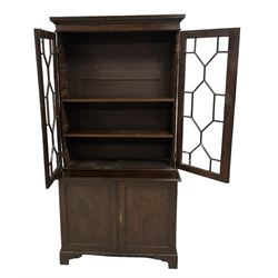 George III figured oak bookcase on cupboard, two astragal glazed doors enclosing adjustable shelves, the base fitted with double panelled cupboard, lower moulded edge on bracket feet