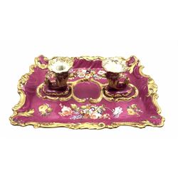 19th century Rockingham style porcelain inkstand, hand-painted with spring flowers on pink ground within a moulded gilt scroll border, with two cornucopia shaped holders to the centre, L34cm