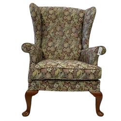 Parker Knoll - two wingback armchairs, upholstered in floral patterned fabric with cabriole supports (2)